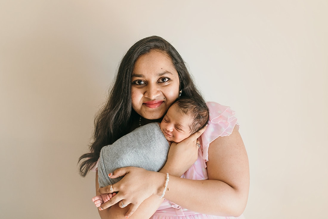 mother holding smiling baby during newborn session in memphis