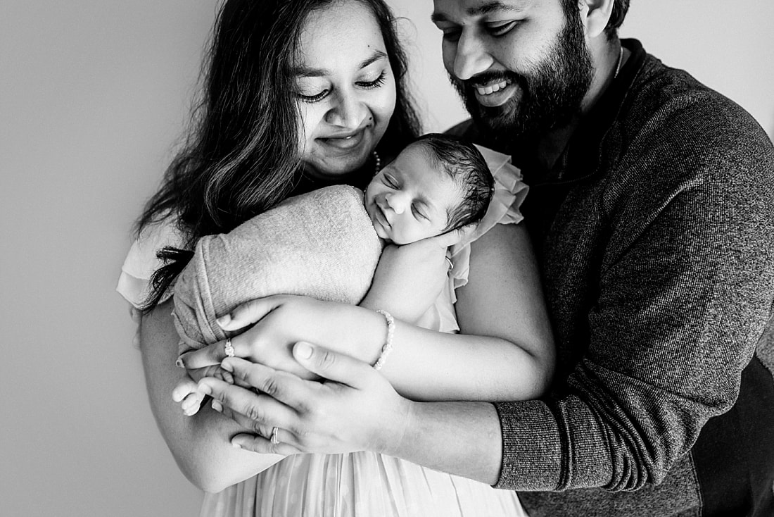 mother and father lovingly gaze at newborn baby during newborn session in memphis