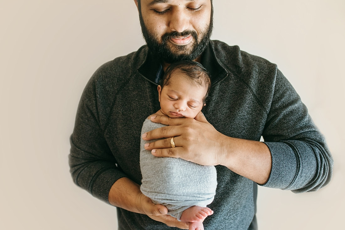father holding new baby during newborn photos in memphis