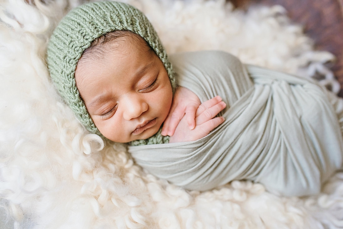 baby boy wearing knit green bonnet during newborn photo session in memphis