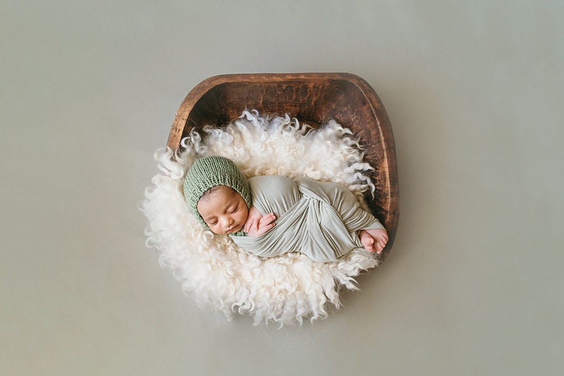 baby boy wearing knit green bonnet during newborn photo session in memphis