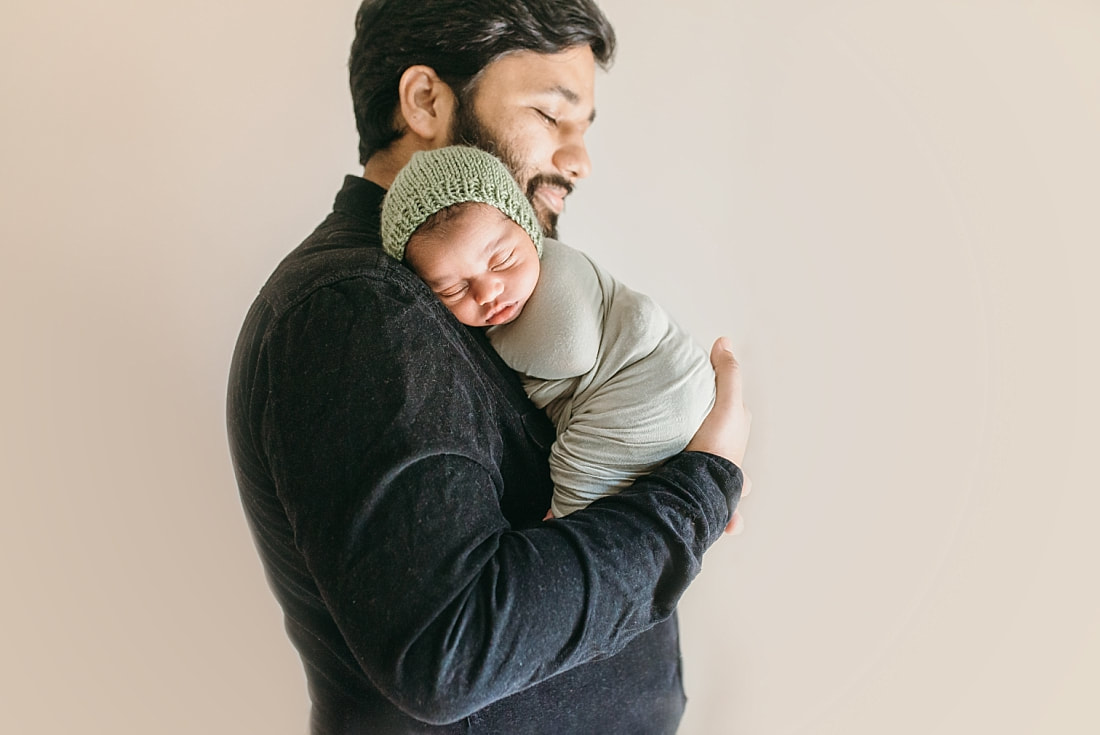 newborn baby boy in daddy's arms during newborn photos in memphis