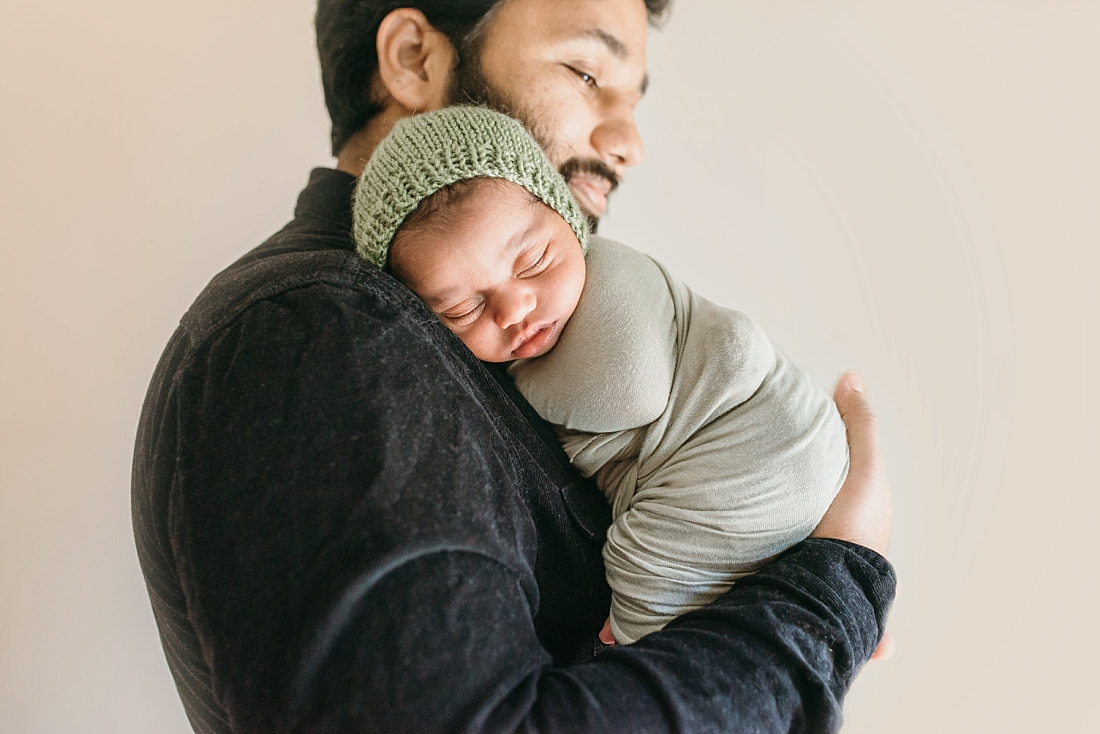 newborn baby boy in daddy's arms for newborn photos in memphis