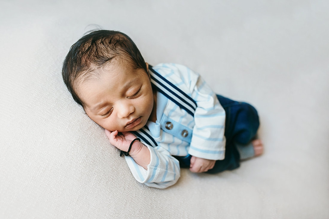 Baby boy posed in suspenders for newborn portrait in memphis