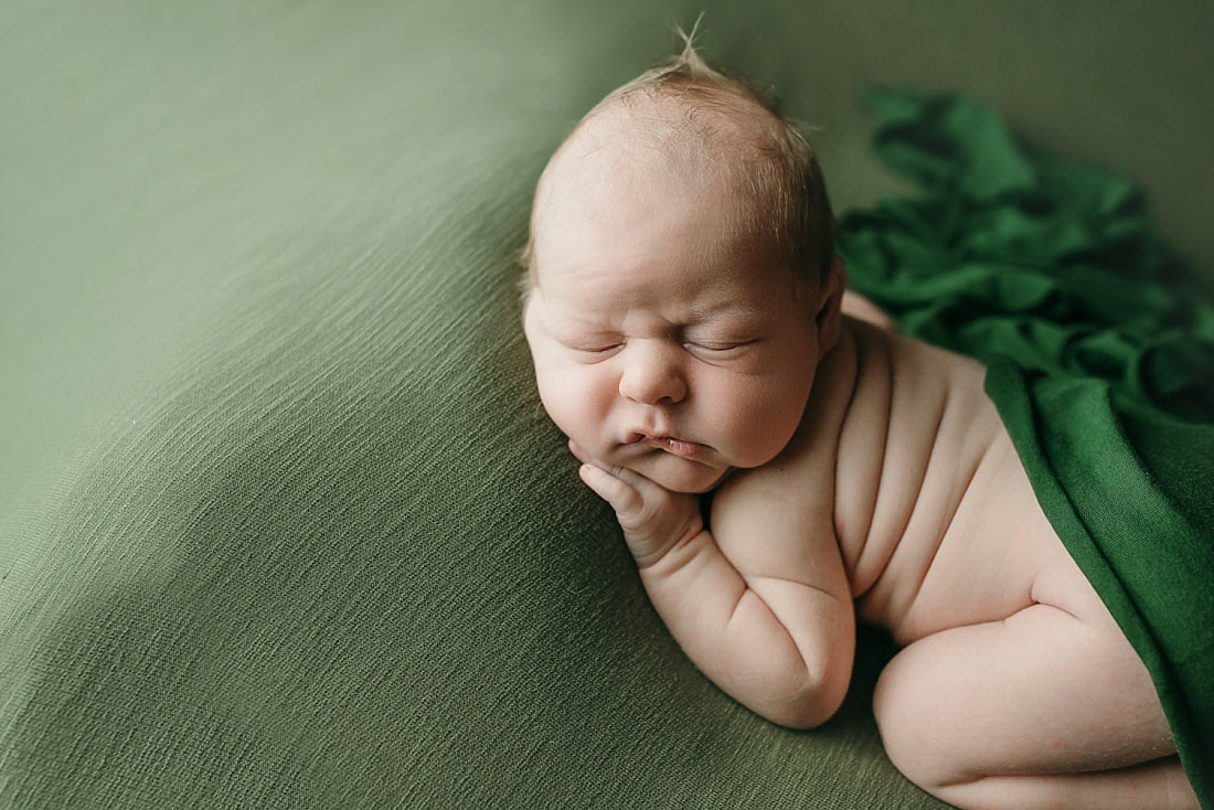 newborn baby boy posed and sleeping on green blanket in Memphis, TN