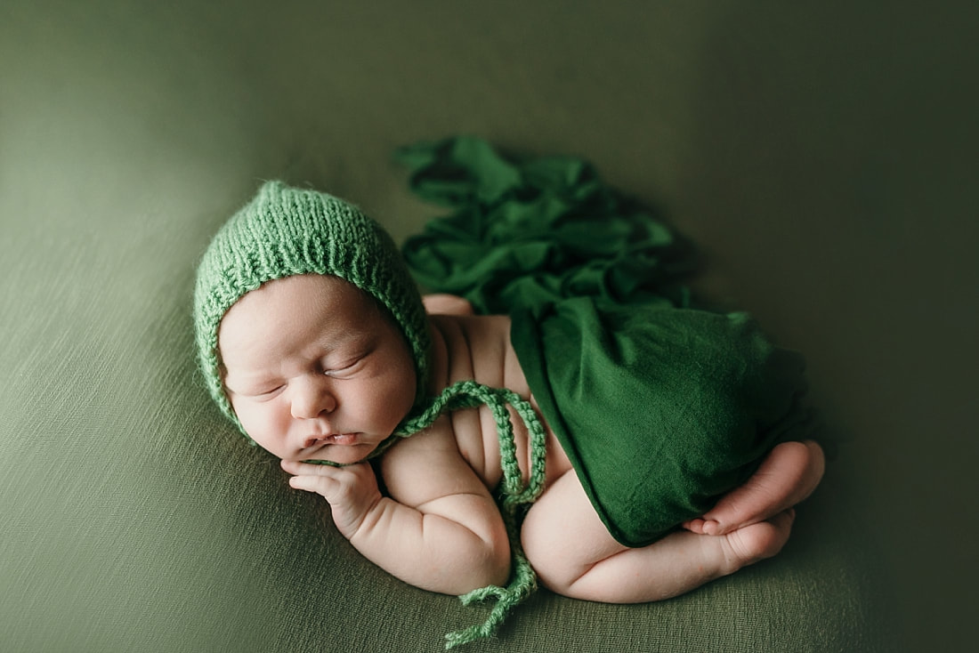 beautiful newborn portrait of a baby boy wearing green bonnet during newborn session in memphis, tn