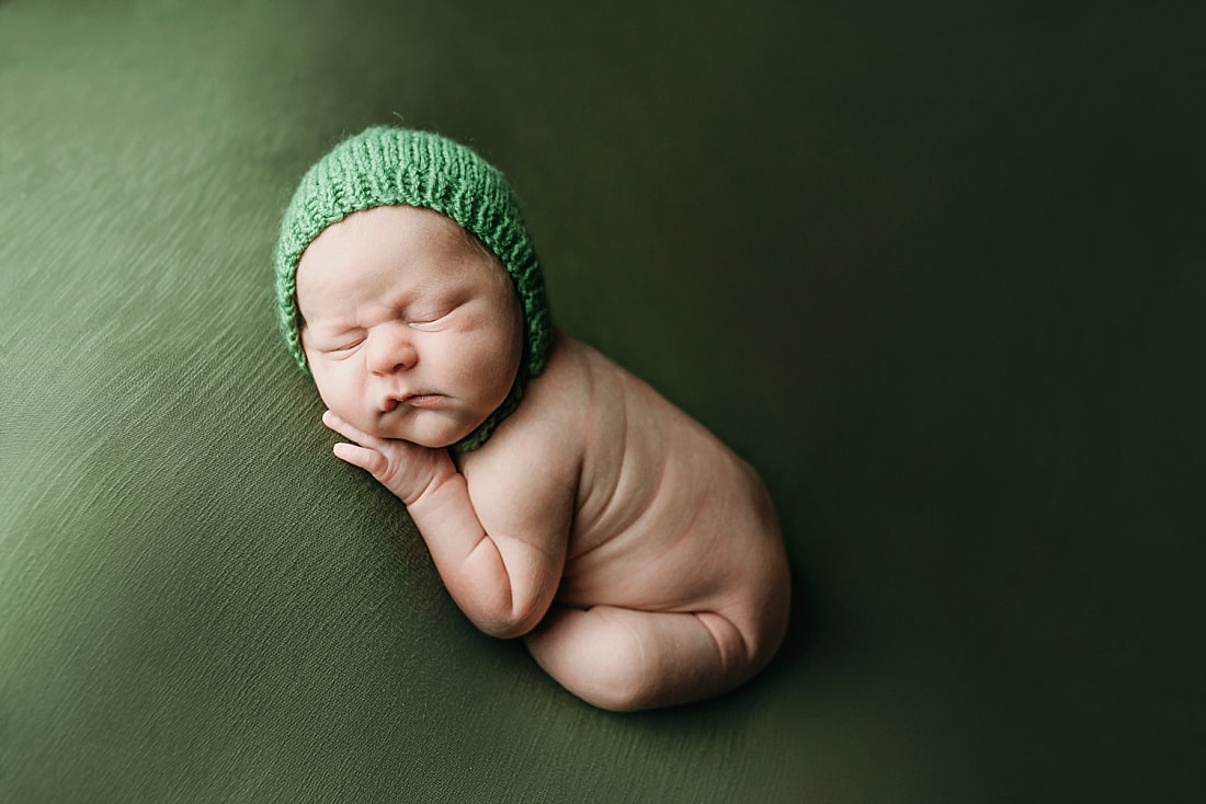newborn baby boy posed and sleeping on green blanket in Memphis, TN