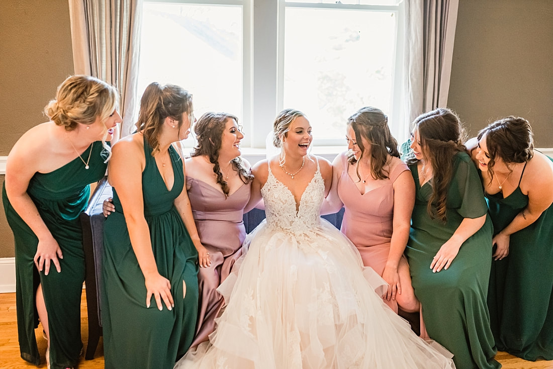bride laughing with her bridesmaids on the couch in the bridal suite + Pink Palace Wedding + Memphis, TN