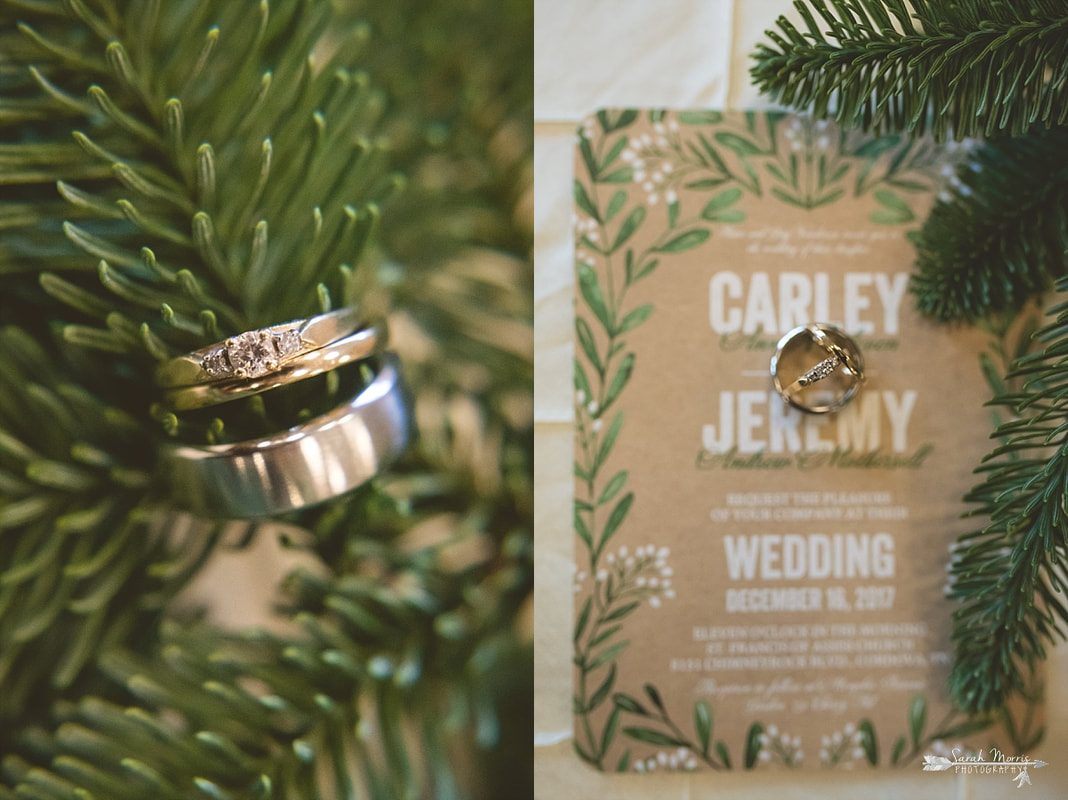 Wedding rings and wedding invitation framed by spruce branches at memphis botanic garden