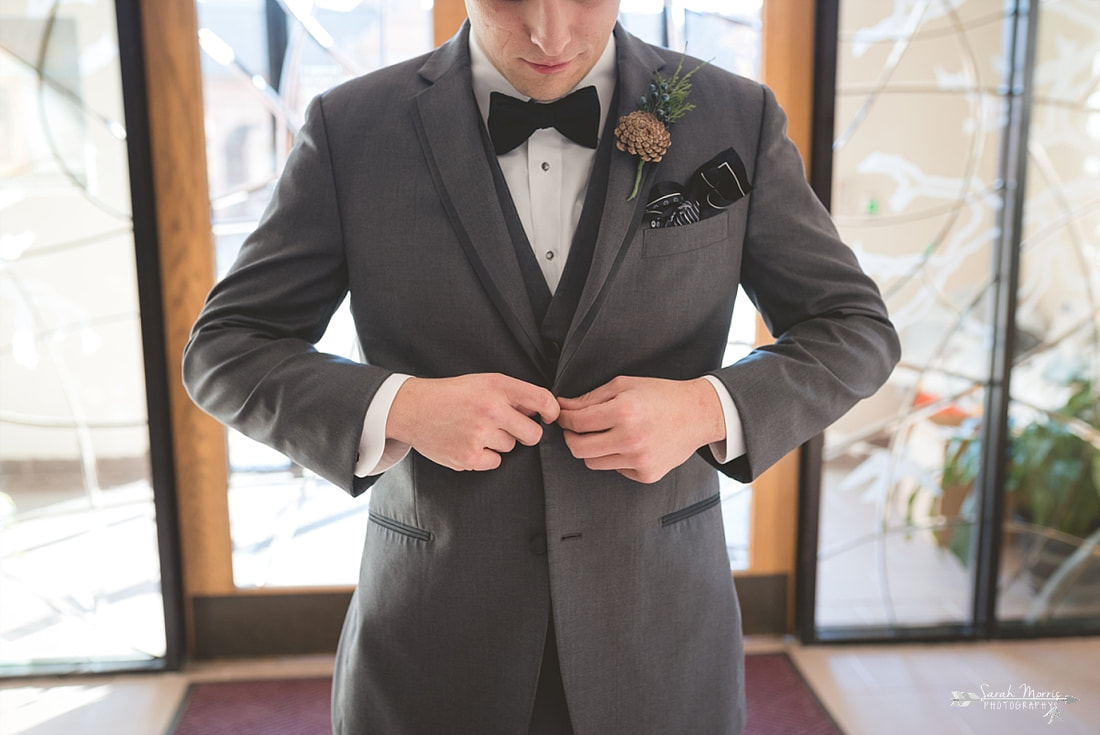 groom buttoning his coat at St. Francis of Assisi Catholic Church