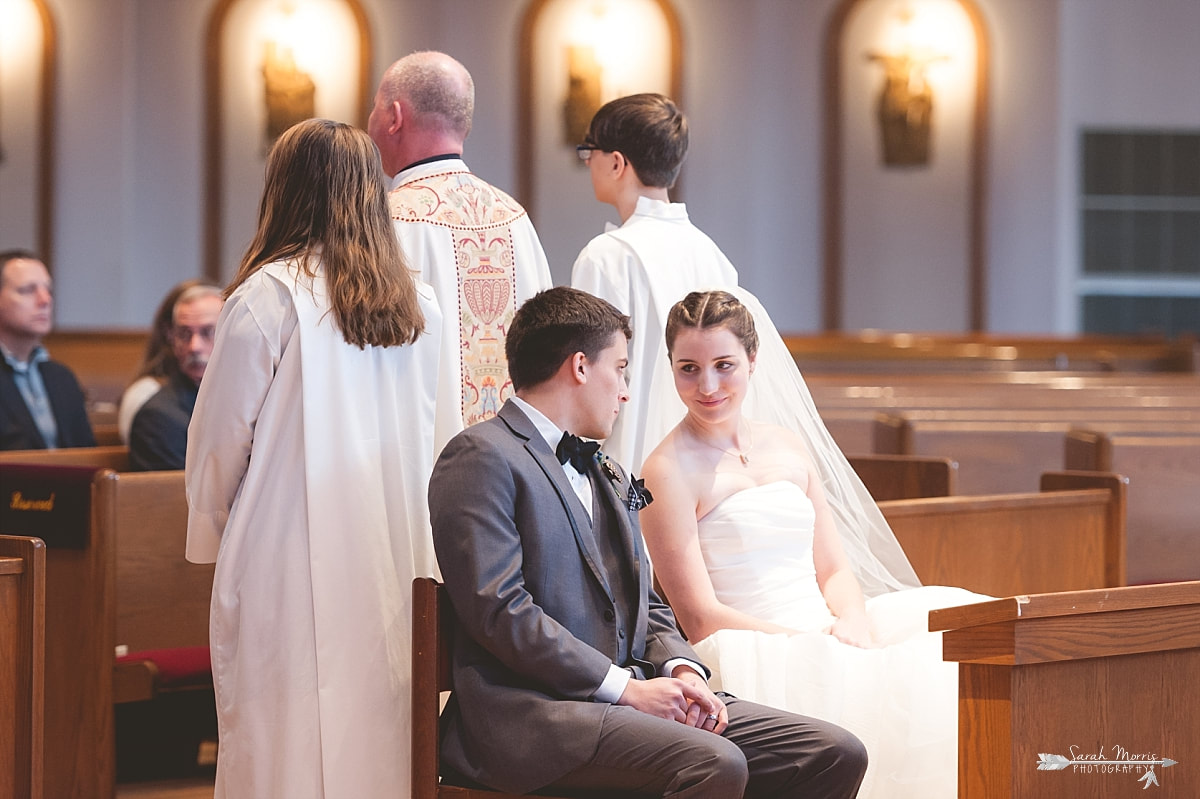 bride and groom sharing a secret during catholic wedding at St. Francis of Assisi Catholic Church