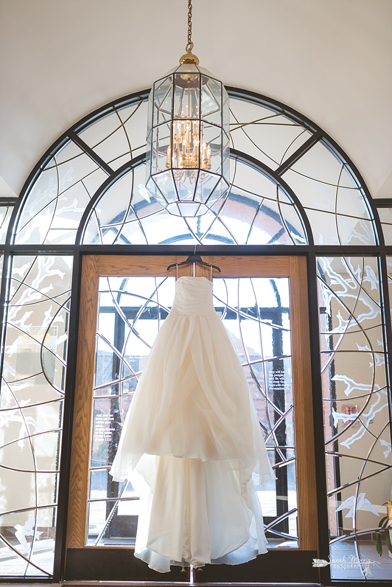 David's Bridal wedding dress hanging in the foyer of St. Francis of Assisi Catholic Church