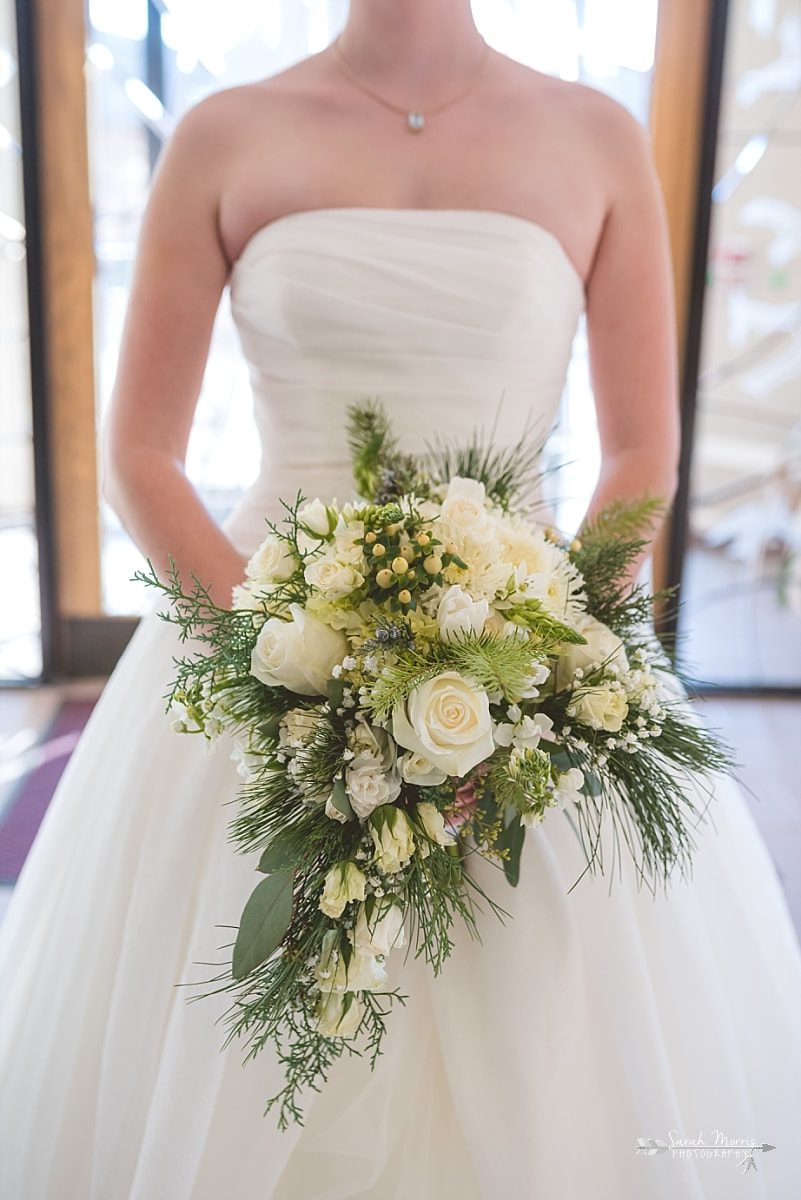 close up of bride holding her winter wedding bouquet by rachel's flowers at St. Francis of Assisi Catholic Church