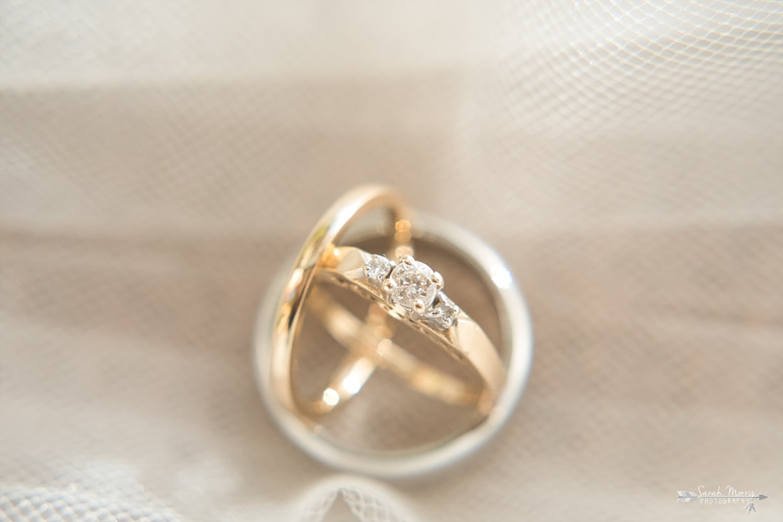 close up of wedding rings on bride's wedding veil 