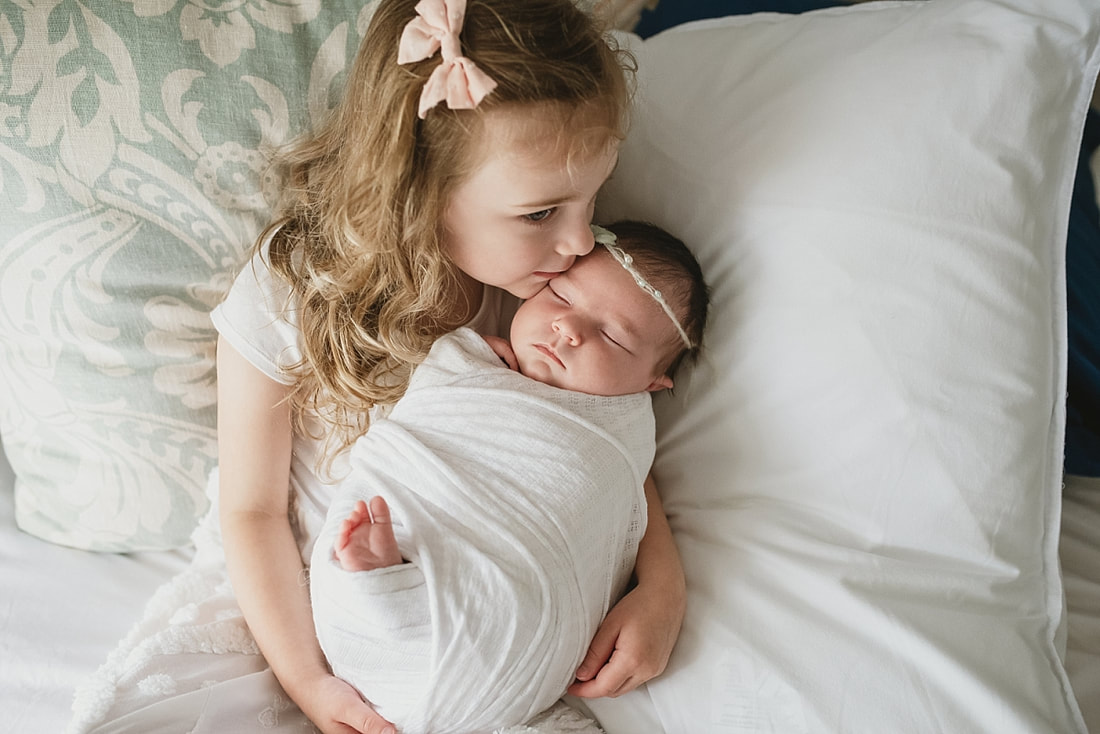 big sister holding newborn baby sister at newborn session in memphis, tn