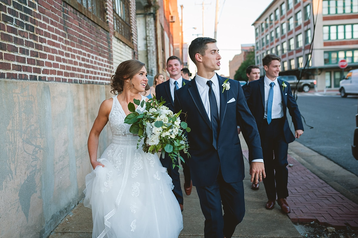 bride and groom walking downtown with their wedding party downtown memphis