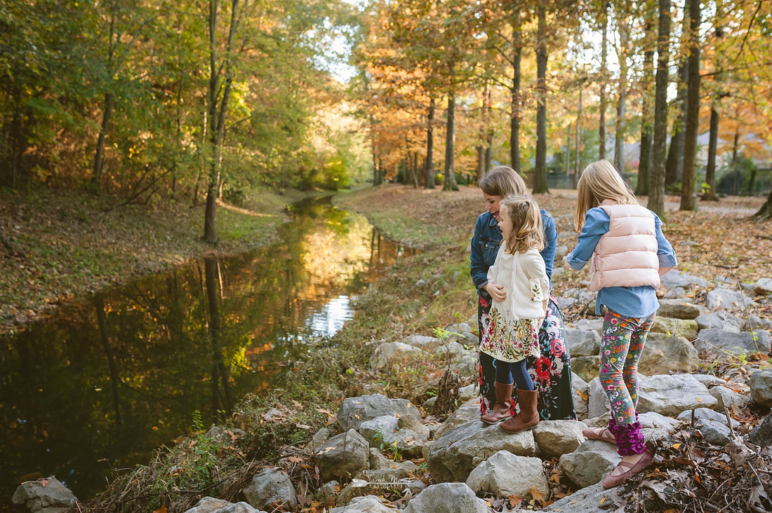 kids throwing sticks in the creek during fall mini session