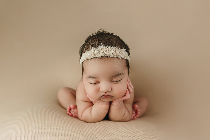 newborn baby girl posed with her head in hands for newborn session in Memphis, TN