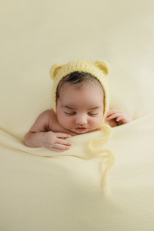 newborn baby girl wearing teddy bear bonnet posed for newborn session in Memphis, TN