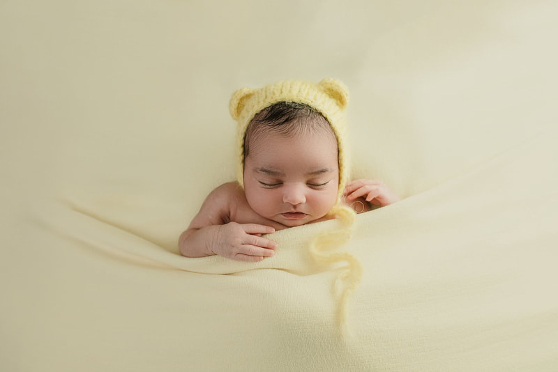 newborn baby girl posed with teddy bear bonnet for newborn session in Memphis, TN