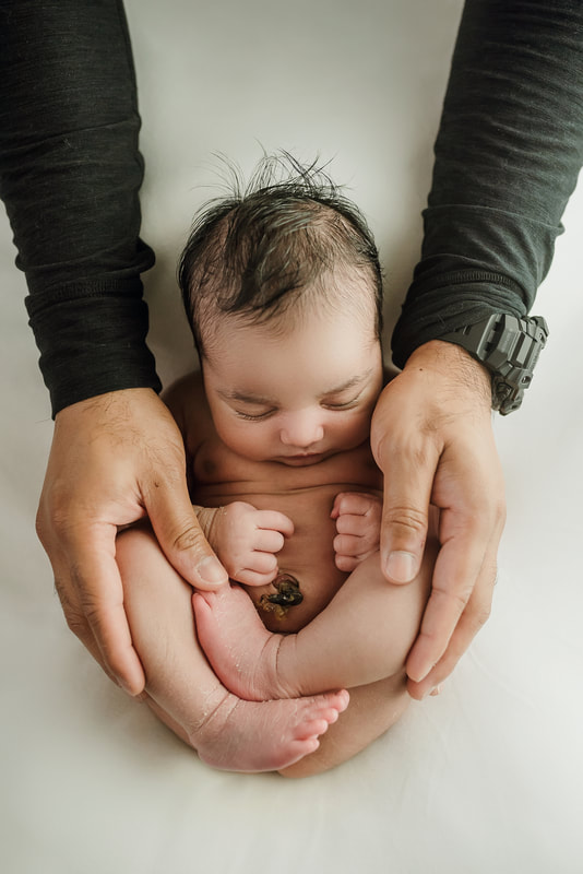 newborn baby girl posed in dad's hands for newborn session in Memphis, TN