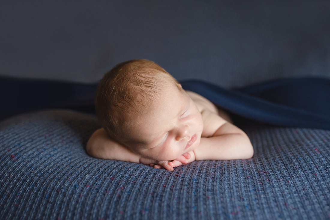 Newborn boy sleeping on blue blanket during newborn photoshoot in Memphis