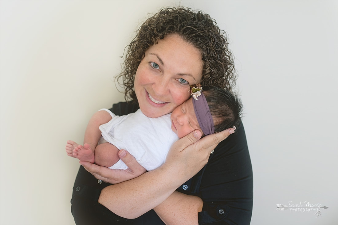 Mother holding baby girl for the lifestyle portion of her newborn photo session