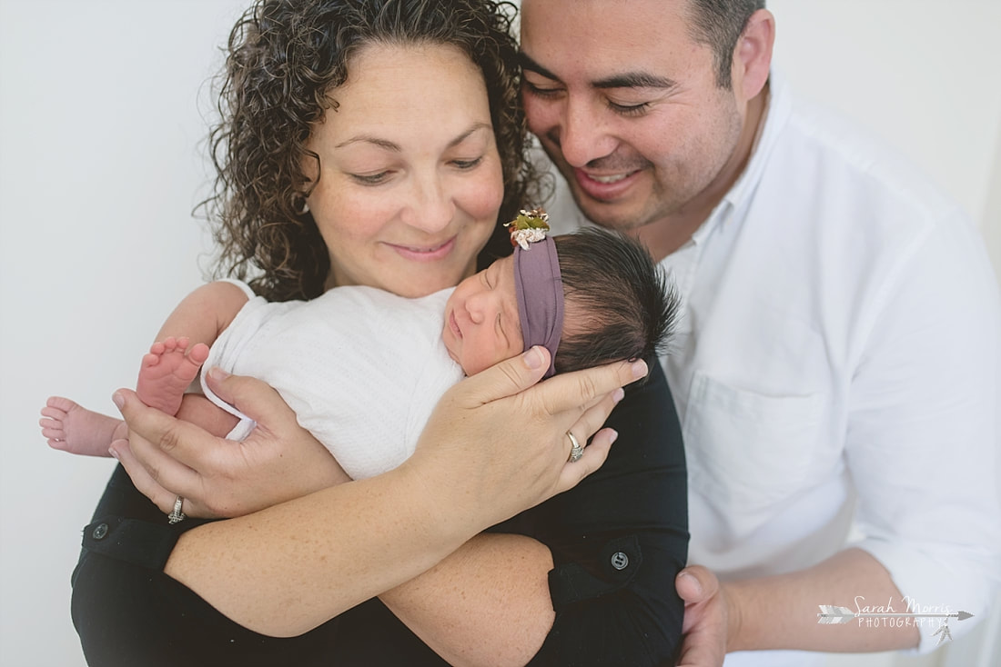 Mother and Father holding baby girl for the lifestyle portion of her newborn photo session