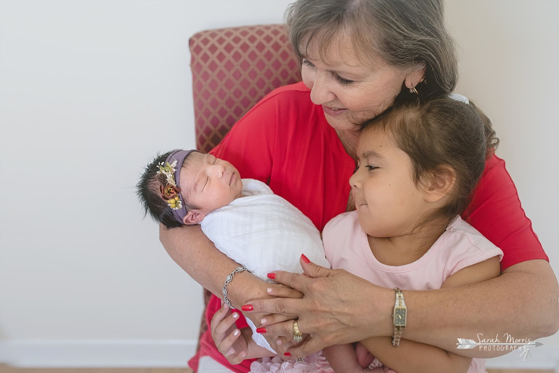 Grandma holding both granddaughters during the lifestyle portion of her newborn photo session