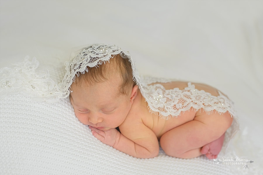 PictureNewborn Photography | Newborn Baby girl posed on white blanket with mom's wedding veil in Memphis, TN