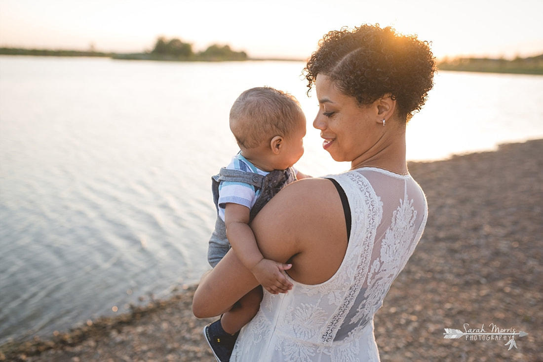 Mother and child on the bank of Patriot Lake at sunset at Shelby Farms Park